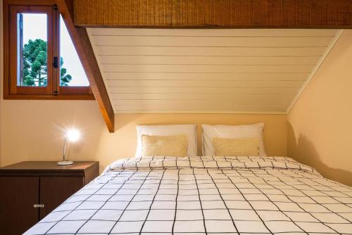 a bedroom with a bed and a window at Apart Central MV in Monte Verde
