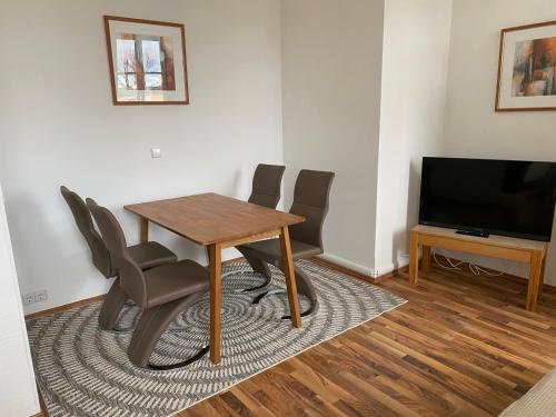 a dining room with a table and chairs and a television at Pension Villa Ostseetraum in Warnemünde