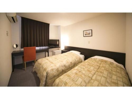 a hotel room with two beds and a desk at Self inn Tokushima kuramoto ekimae - Vacation STAY 19498v in Tokushima