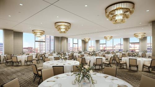 a banquet hall with white tables and chairs and chandeliers at Jasper Hotel in Fargo