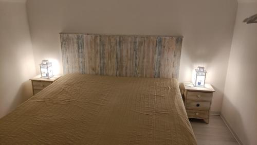 a bedroom with a bed with two nightstands and two lamps at Casa Vacanze Sempreinsieme Santa Tecla in Santa Tecla