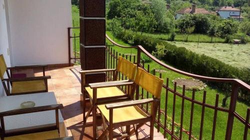 a balcony with two chairs and a view of a field at Къща за гости "Край Реките" in Apriltsi