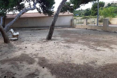 a courtyard with two trees and a bench at Appartement calme Entre Terre et Mer proche plage in Fleury