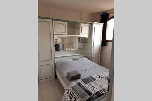 małą sypialnię z łóżkiem i lodówką w obiekcie Appartement calme Entre Terre et Mer proche plage w mieście Fleury