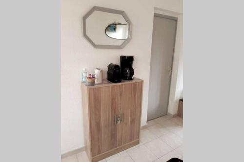 a bathroom with a mirror and a wooden cabinet at Appartement calme Entre Terre et Mer proche plage in Fleury