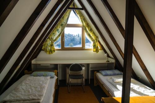a attic room with two beds and a window at Haus 4-Jahreszeiten in Siegsdorf