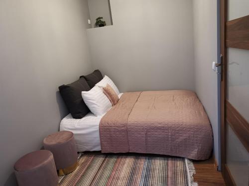 1 dormitorio pequeño con 1 cama y 2 taburetes en Przystanek Ustrzyki, en Ustrzyki Dolne