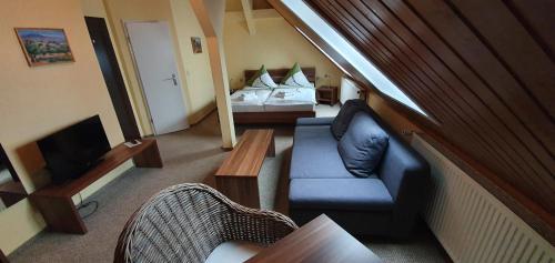 uma sala de estar com um sofá e uma cama em Restaurant & Hotel Olive em Greifswald