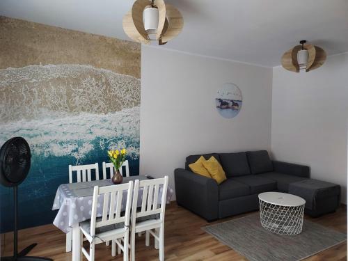 a living room with a couch and a table at Apartament Sun&Fun - Rowy in Rowy
