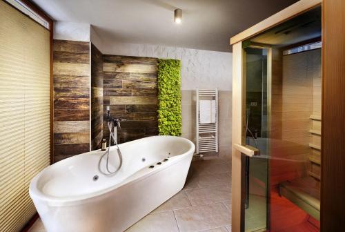 y baño con bañera blanca y ducha. en Chalet Jasná Wellness Apartment Maxim jacuzzi & sauna en Demanovska Dolina