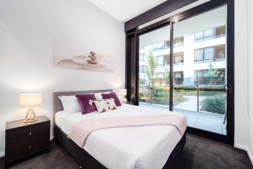 1 dormitorio con cama y ventana grande en Kerridge St Apartments by Urban Rest en Kingston 