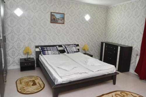 a bedroom with a large bed with white sheets at Casa Simescu II in Caransebeş