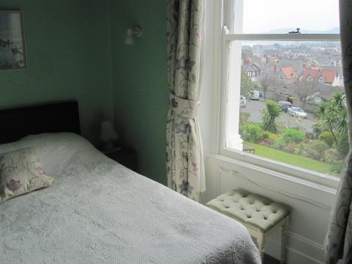 a bedroom with a bed and a window at Bron Orme Private Hotel in Llandudno