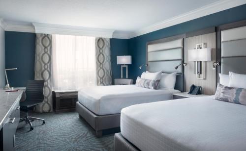 um quarto de hotel com duas camas e uma secretária em Rosen Centre Hotel Orlando Convention Center em Orlando