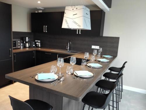 una cocina con una mesa con copas de vino. en DELARNOR - Confort et sérénité en Saint-Quentin