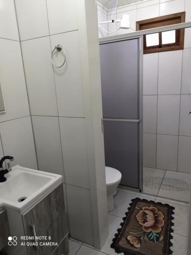 ein kleines Bad mit WC und Waschbecken in der Unterkunft Casa de Praia. Lugar sossegado para recarregar as energias. in Passo de Torres
