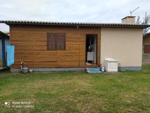 a small house with a yard in front of it at Casa de Praia. Lugar sossegado para recarregar as energias. in Passo de Torres