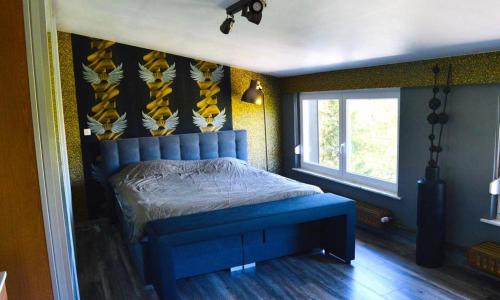 a bedroom with a blue bed and a window at Maison de vacances privative à louer in Aywaille
