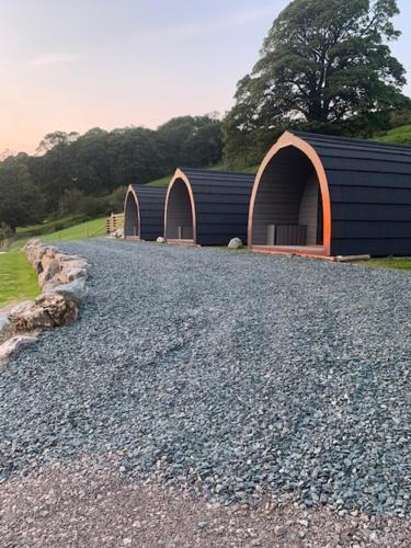 
a dirt road next to a stone wall with a fire hydrant at Highside Glamping Pods in Keswick
