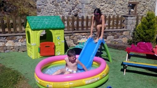 una mujer jugando con un chico en una piscina en un patio trasero en Apartamentos Caloca, en Caloca