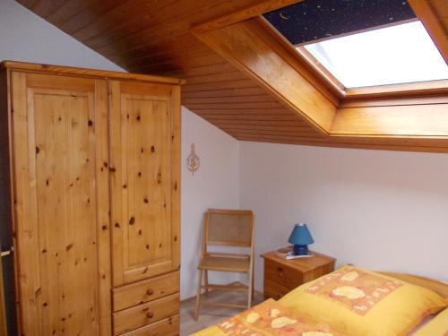 a bedroom with a skylight and a bed and a chair at Ferienhaus Sequoia Hahnenklee in Hahnenklee-Bockswiese