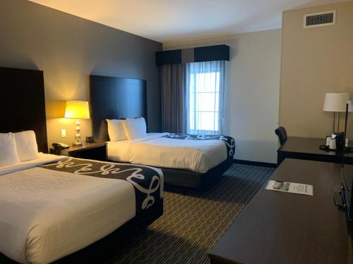 a hotel room with two beds and a window at La Quinta by Wyndham Billings in Billings