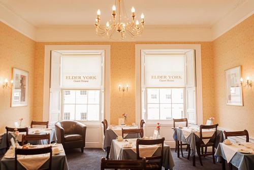 愛丁堡的住宿－老約克賓館，一间带桌椅和吊灯的用餐室
