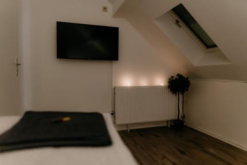 a room with a bed and a tv on the wall at Monteurzimmer Pavan E2-KEINE Ferienwohnung in Saarlouis