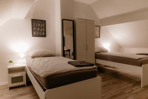 a bedroom with two beds and a mirror at Monteurzimmer Pavan E2-KEINE Ferienwohnung in Saarlouis