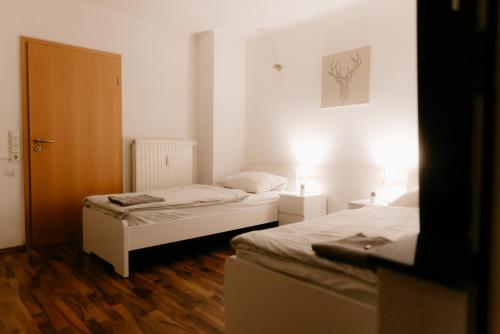 薩爾路易的住宿－Monteurzimmer Pavan M1-KEINE Ferienwohnung，铺有木地板的小客房内的两张床