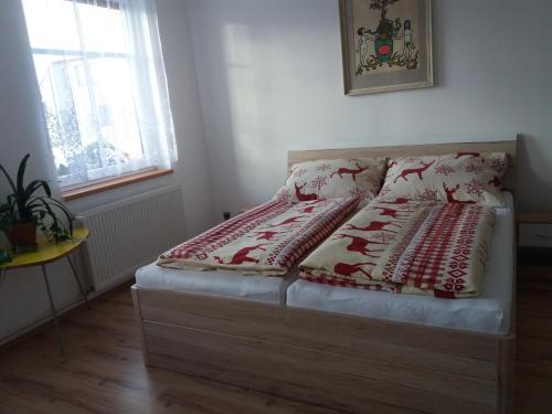 uma cama com um cobertor vermelho e branco em Apartmán Formanka em Liberec