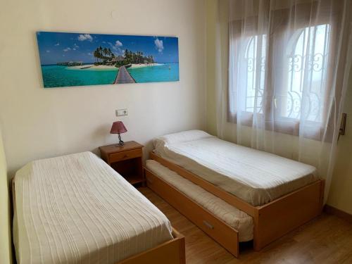 Un dormitorio con dos camas individuales y una ventana. en Villa Sonrisa de Oro - private swimming pool, en Miami Platja