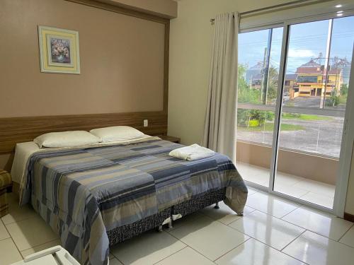 Restinga Sêca的住宿－Pousada Fuzer，一间卧室设有一张床和一个大窗户