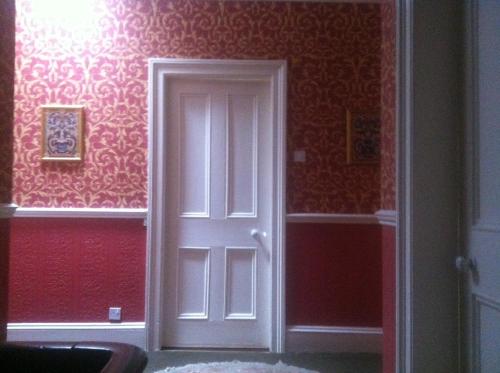 uma porta branca num quarto com paredes vermelhas em Ivyleigh House em Portlaoise