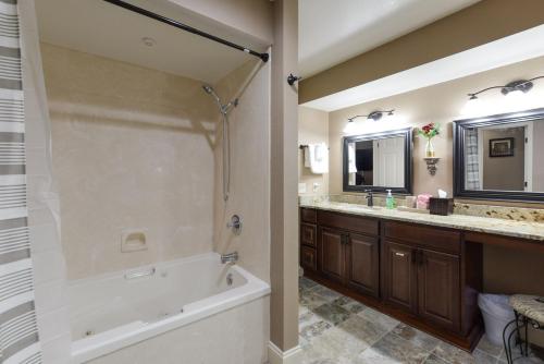 a bathroom with a tub and a shower and a sink at Luxury Condos at Thousand Hills - Heart of Branson - Beautifully remodeled - Spacious and Affordable in Branson