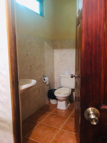 a bathroom with a toilet and a sink at Chosa Manglar Suites & Cabins in Puerto Jiménez