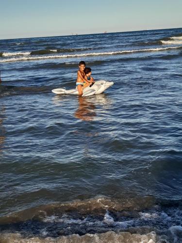 a woman sitting on a surfboard in the ocean at Yasmine in El Jadida
