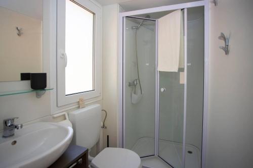 uma casa de banho com um chuveiro, um WC e um lavatório. em Adria village Baško polje em Baška Voda