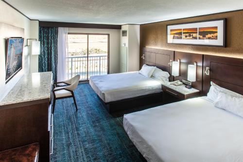 a hotel room with two beds and a desk at Don Laughlin's Riverside Resort & Casino in Laughlin