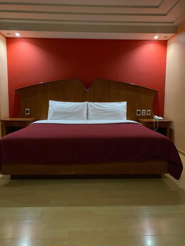 a bedroom with a bed with a red wall at HOTEL MARIA RICO in Mexico City