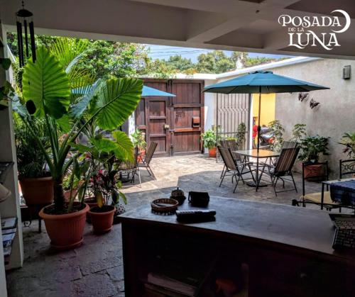 a patio with a table and chairs and an umbrella at Hotel Posada de la Luna in Antigua Guatemala