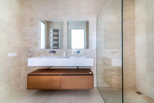 een badkamer met een wastafel en een spiegel bij NEW Luxurious 4-BDRM Villa next to Beach/Golf — La Finca in Marbella