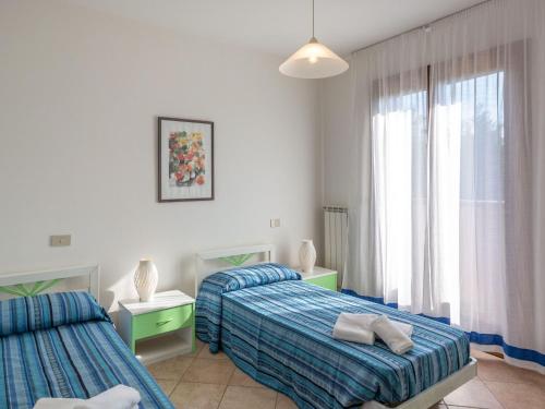 アルバレッラ島にあるBelvilla by OYO Village Albarella V3のベッドルーム1室(ベッド2台、窓付)