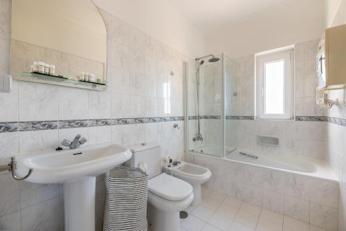 a white bathroom with a sink and a toilet at T2 Oásis Parque, Piscinas, Jacuzzi e ténis! in Portimão