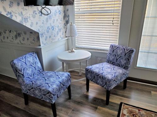 a room with two chairs and a table and a lamp at Anchor Inn Boutique Hotel in Put-in-Bay