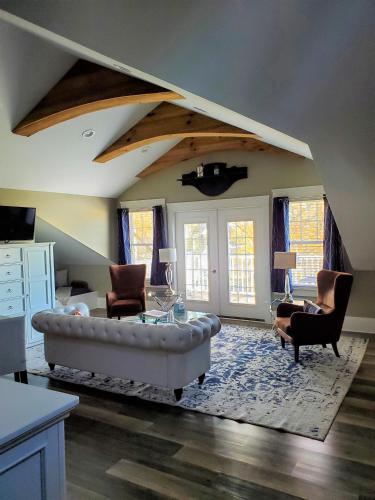 a living room with a white couch and chairs at Anchor Inn Boutique Hotel in Put-in-Bay