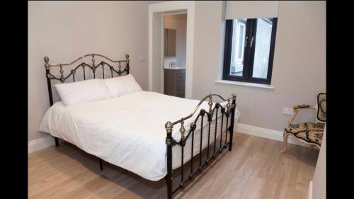 - une chambre avec un lit doté de draps blancs et une fenêtre dans l'établissement Lavender Cottage - 2 Bedroom Home, à Newbridge