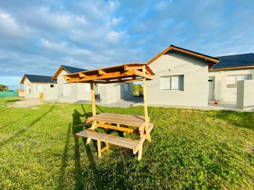 a picnic table in a yard in front of a house at Cabañas Mangata in Mar de Cobo