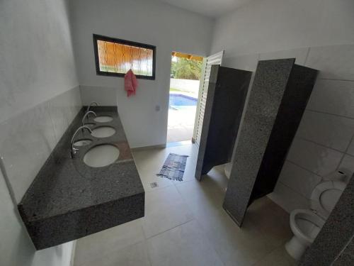 a bathroom with three sinks and two toilets at Chácara com Piscina-JundiaÍ SP in Jundiaí