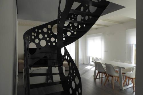 - un escalier en colimaçon dans une chambre avec une table et des chaises dans l'établissement Hamabi, à Hendaye